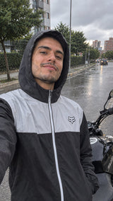Chaqueta cortavientos negra con capucha puesta en día de lluvia