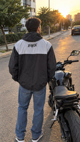 Espalda de chaqueta cortavientos negra con panel gris y logo